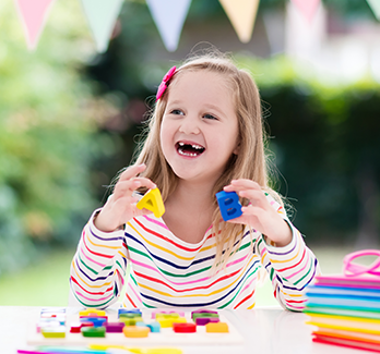 Smiling girl with letter toys